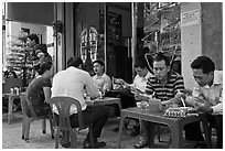 Men eating breakfast on the street. Ho Chi Minh City, Vietnam (black and white)