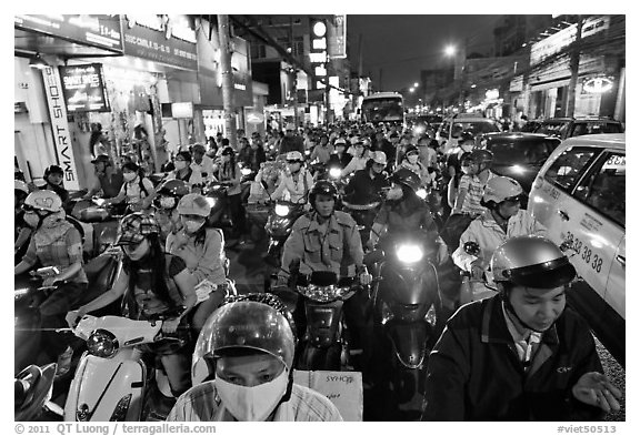 Street packed with motorcycles and vehicles at dusk. Ho Chi Minh City, Vietnam