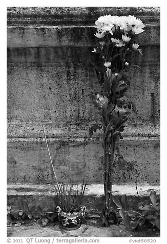 Incense and flowers next to tomb. Ben Tre, Vietnam (black and white)