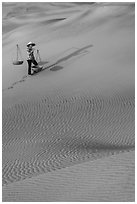 Woman with yoke baskets on sands. Mui Ne, Vietnam ( black and white)
