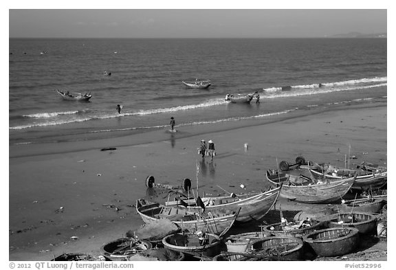 Boats and fishermen on beach. Mui Ne, Vietnam (black and white)