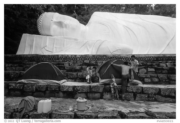 Pilgrims pitch tent below reclining Buddha statue. Ta Cu Mountain, Vietnam (black and white)