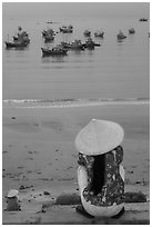 Woman with conical hat sitting above fishing fleet. Mui Ne, Vietnam ( black and white)