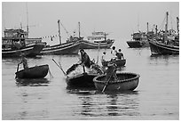 Men use round woven boats to disembark from fishing boats. Mui Ne, Vietnam ( black and white)