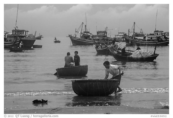 Fishermen on roundboats and fishing fleet. Mui Ne, Vietnam (black and white)