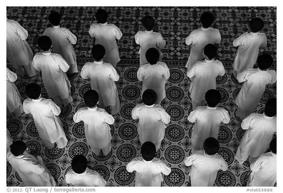 Worshippers dressed in white stand in rows in Cao Dai temple. Tay Ninh, Vietnam (black and white)