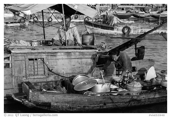 Woman serving food across boats, Cai Rang floating market. Can Tho, Vietnam