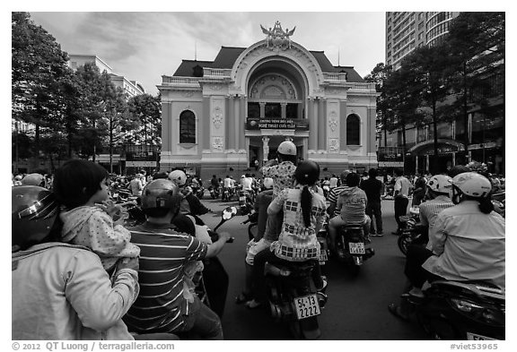 Families gather on motorbikes to watch performance in front of opera house. Ho Chi Minh City, Vietnam (black and white)