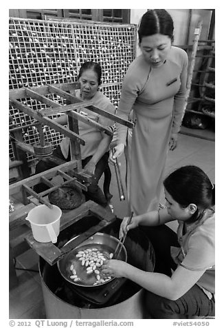 Workers demonstrate silkworm processing. Hoi An, Vietnam (black and white)