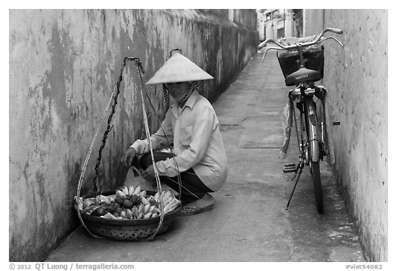 Fruit vendor in narrow alley. Hoi An, Vietnam