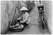 Fruit vendor in narrow alley. Hoi An, Vietnam ( black and white)