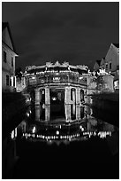Illuminated Japanese covered bridge reflected in canal. Hoi An, Vietnam ( black and white)