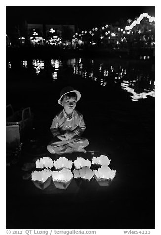 Boy selling candle lanterns by the river. Hoi An, Vietnam (black and white)