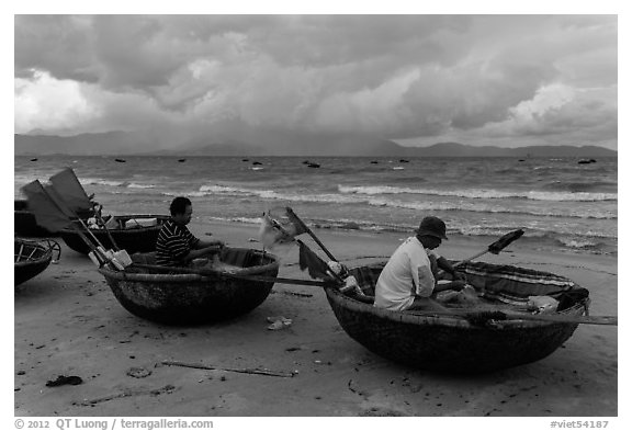 Fishermen mending nets in coracle boats. Da Nang, Vietnam (black and white)