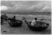Fishermen mending nets in coracle boats. Da Nang, Vietnam (black and white)
