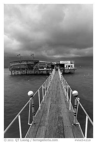 Boarwal, offshore restaurant, and threatening clouds. Vietnam (black and white)