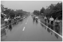Riders wearing colorful ponchos on wet road on Hwy 1 south of Hue. Vietnam ( black and white)