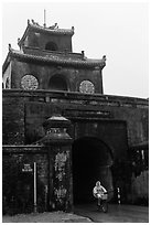 Biking through citadel gated entrance in the rain. Hue, Vietnam ( black and white)