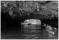 Paddling through Luon Cave tunnel. Halong Bay, Vietnam ( black and white)