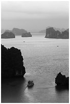 Tour boat navigating between islets. Halong Bay, Vietnam (black and white)