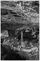 Tourists walking in cavernous chamber, Sungsot cave. Halong Bay, Vietnam ( black and white)