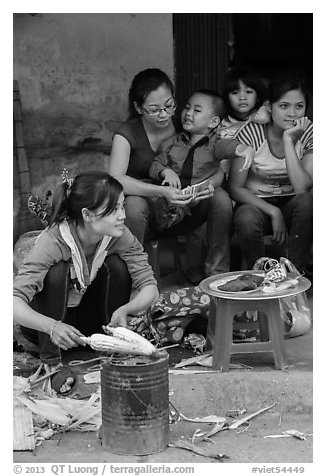 Woman roasting corn in the street. Bat Trang, Vietnam
