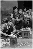 Woman roasting corn in the street. Bat Trang, Vietnam (black and white)