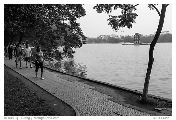 Walking for exercise around Hoang Kiem Lake at dawn. Hanoi, Vietnam (black and white)