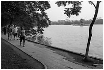Walking for exercise around Hoang Kiem Lake at dawn. Hanoi, Vietnam ( black and white)