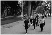 Numerous people walk counter-clockwise around Hoang Kiem Lake. Hanoi, Vietnam ( black and white)