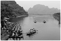 Groups leaving wharf on boats, Trang An. Ninh Binh,  Vietnam (black and white)