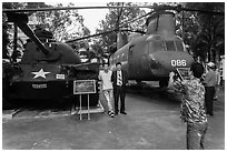 Tourists pose with tanks and helicopters, War Remnants Museum, district 3. Ho Chi Minh City, Vietnam ( black and white)