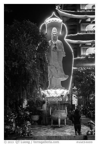 Praying outside Quoc Tu Pagoda at night, district 10. Ho Chi Minh City, Vietnam (black and white)