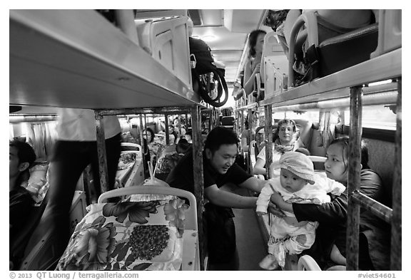 Couple passing baby on sleeper bus. Vietnam (black and white)