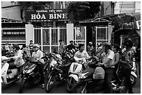 School entrance with parents waiting on motorbikes. Ho Chi Minh City, Vietnam (black and white)