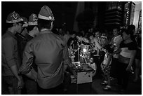 People gather around street hawker on Christmas eve. Ho Chi Minh City, Vietnam (black and white)