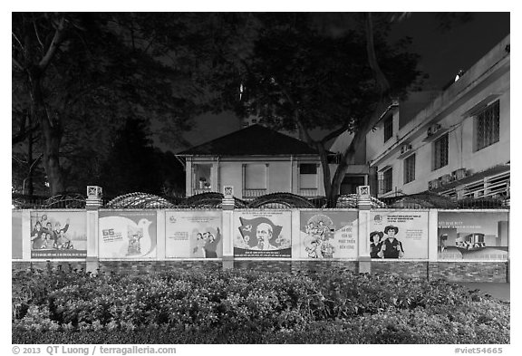 Fenced buildings with propaganda posters at night. Ho Chi Minh City, Vietnam