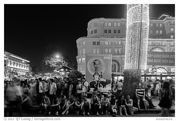Revellers sitting on street, New Year eve. Ho Chi Minh City, Vietnam