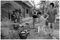 Vacationers frying fish in resort. Mui Ne, Vietnam (black and white)