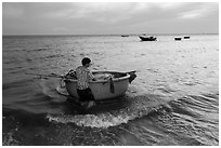 Man holding coracle boat. Mui Ne, Vietnam ( black and white)