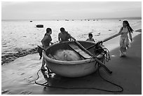 Family around their coracle boat. Mui Ne, Vietnam ( black and white)