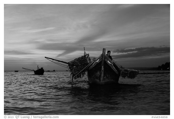 Man on fishing boat at sunset. Mui Ne, Vietnam (black and white)