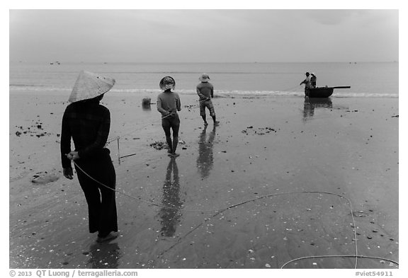 Fishermen pulling line onto beach. Mui Ne, Vietnam (black and white)