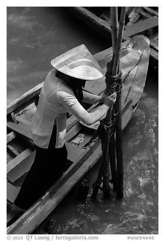Woman in Ao Ba Ba holding from boat to bamboo poles. My Tho, Vietnam (black and white)