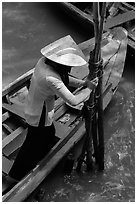 Woman in Ao Ba Ba holding from boat to bamboo poles. My Tho, Vietnam ( black and white)
