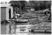 Man paddling out of houseboat. My Tho, Vietnam ( black and white)