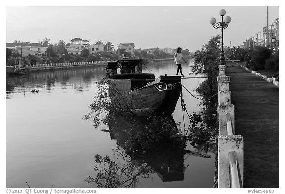 Woman in high heels walking out of barge. Tra Vinh, Vietnam (black and white)