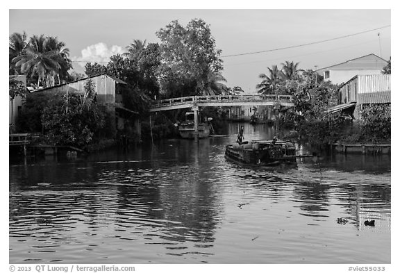 Barge and canal-side houses. Mekong Delta, Vietnam