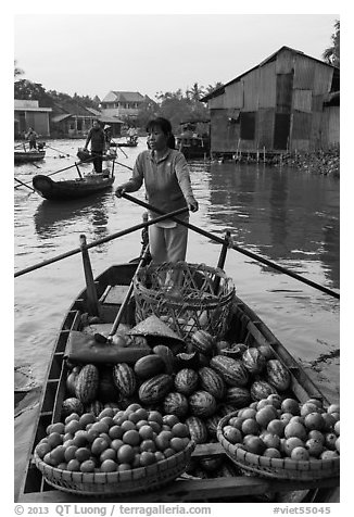 Woman paddles boat loaded with fruits and vegetable, Phung Diem. Can Tho, Vietnam