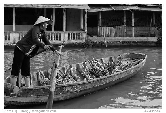 Woman paddling sampan boat loaded with bananas. Can Tho, Vietnam (black and white)